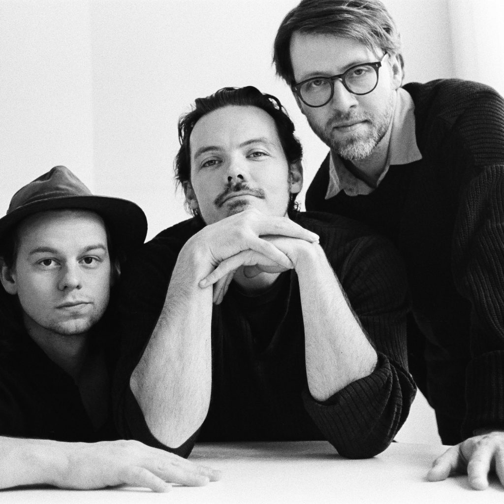 Pictured are the three members of the group Half Moon Run in a black and white contrast. 