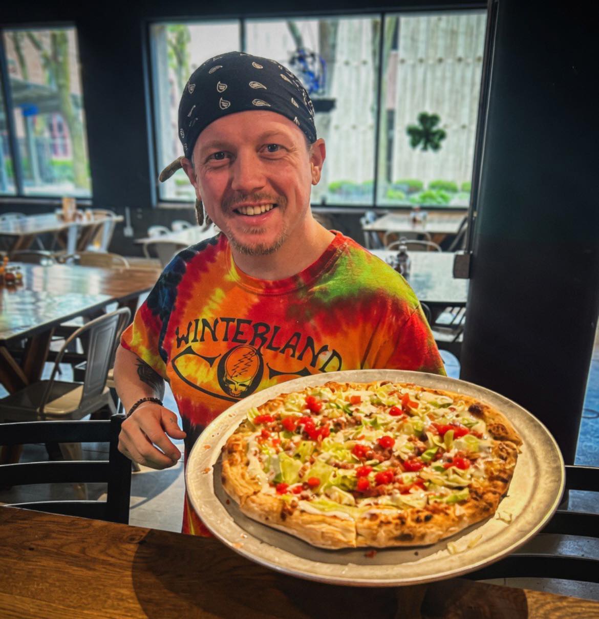 A member of the staff happily serves up delicious pizza at Murph and Mary's Pub in Newton, Iowa
